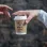 one person giving  cup of coffee to another