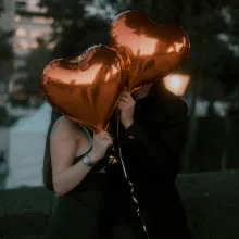 couple holding heart baloons