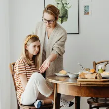 mother teaching daughter table manners