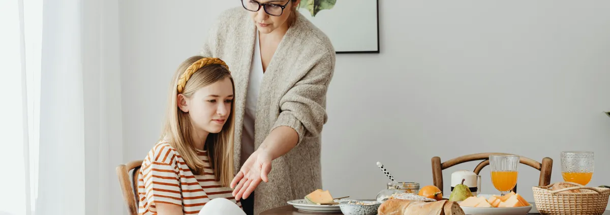 mother teaching daughter table manners