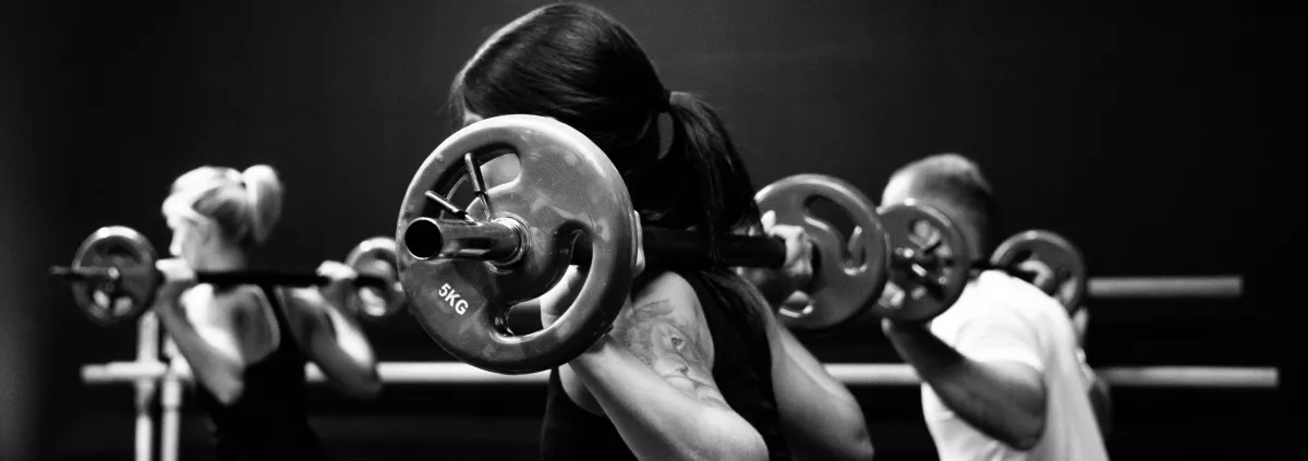 3 people doing lunges with barbells